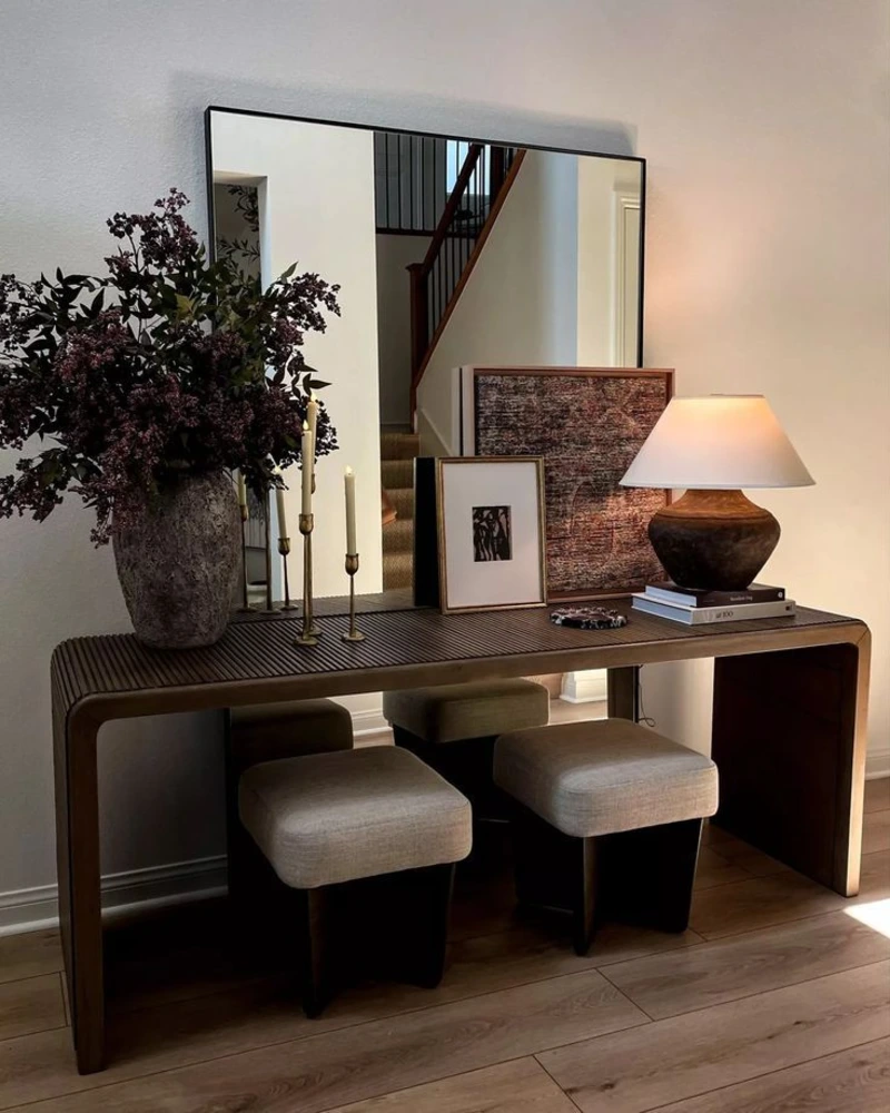 Ribbed Wood Console with Oversized Mirror, Stone Vase, and Warm Table Lamp