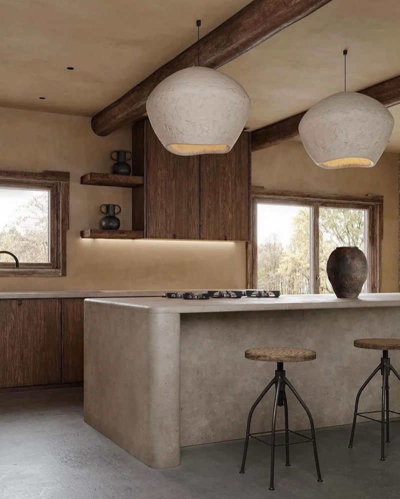 Rounded Concrete Island with Textured Gourd Pendants and Dark Oak Cabinetry