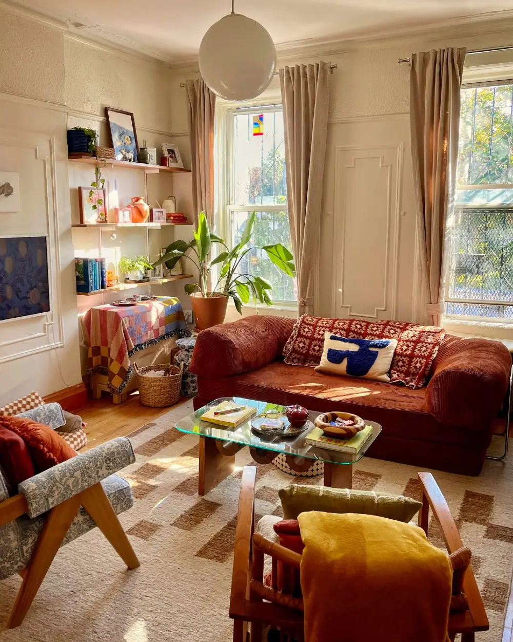 Rust Velvet Sofa with Glass Coffee Table and Sunlit Gallery Wall Living Room