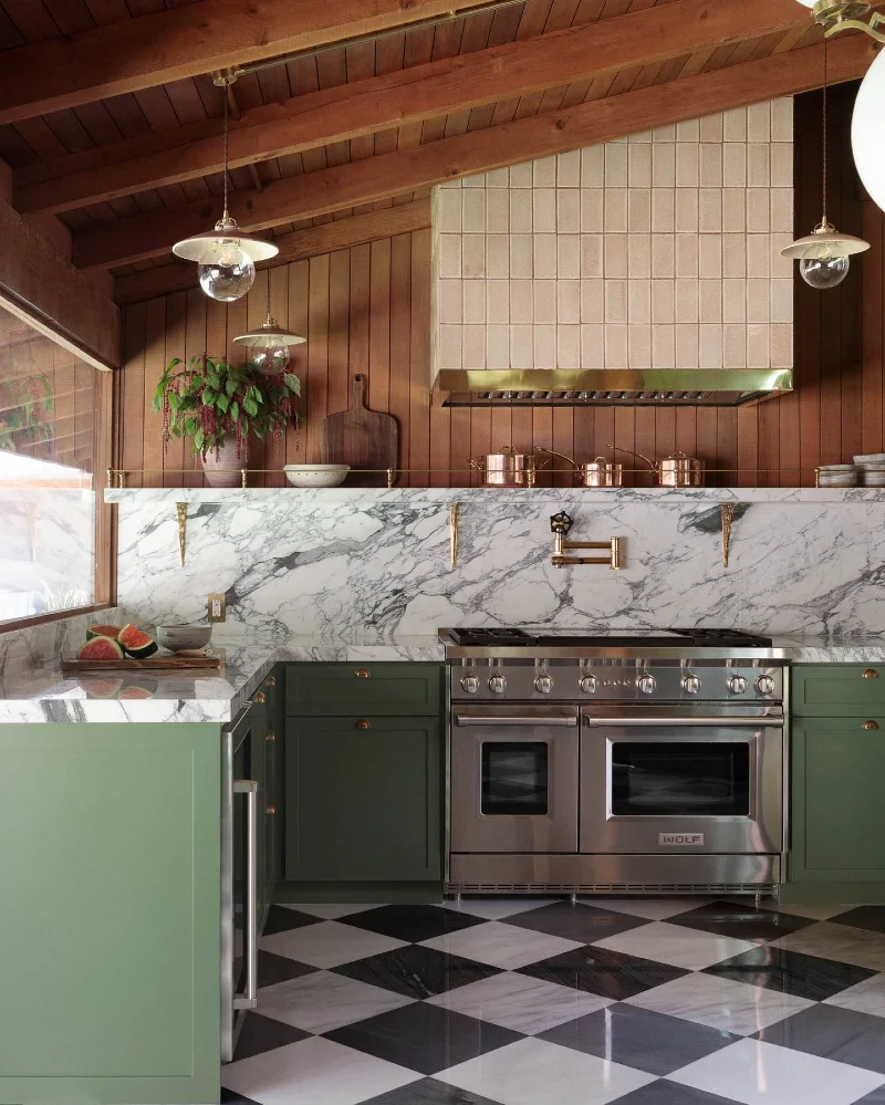 Sage Green Cabinetry With Tiled Slanted Range Hood and Checkerboard Marble Floor