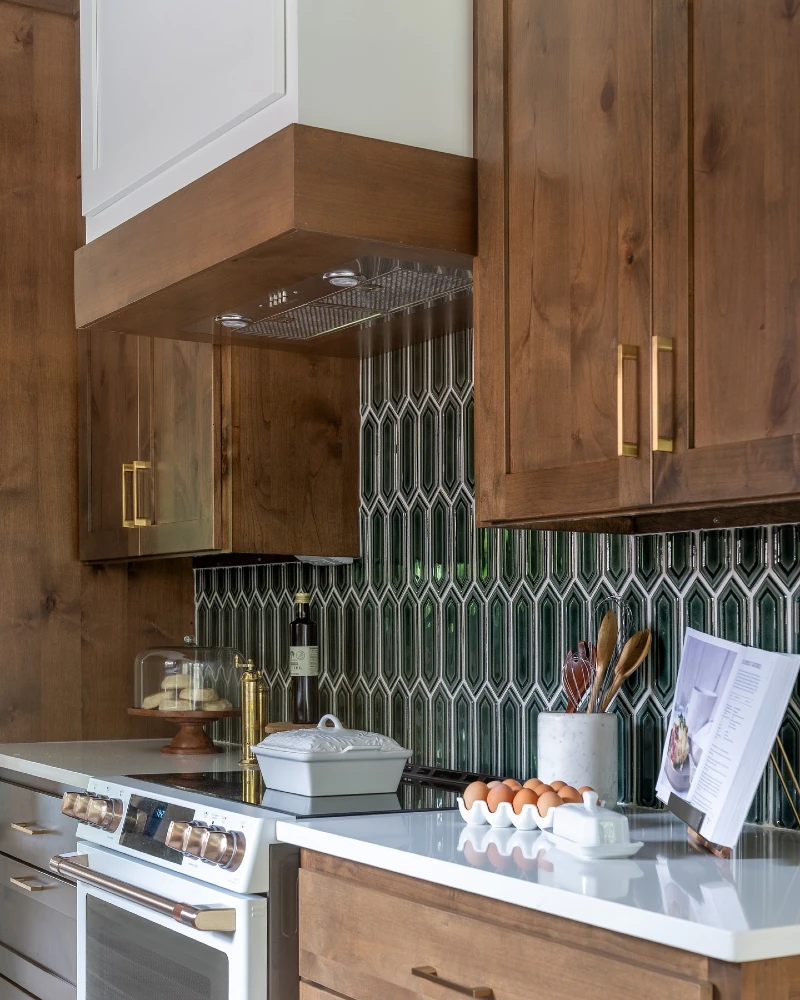 Sculpted Emerald Geometric Tile Backsplash with Walnut Cabinets and Vertical Wood Hood Trim