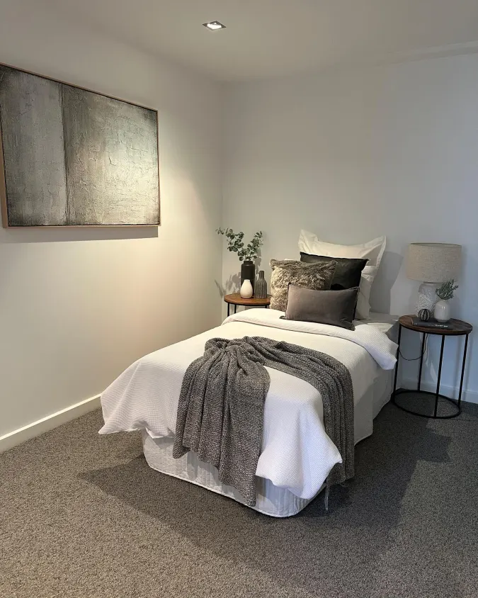 Single Bed with Large Abstract Art and Round Black Side Tables