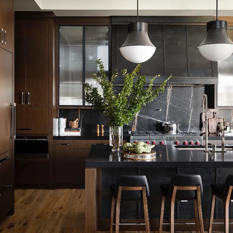 Smoked Oak Cabinetry With Industrial Metal Vent Hood and Black Marble Backsplash