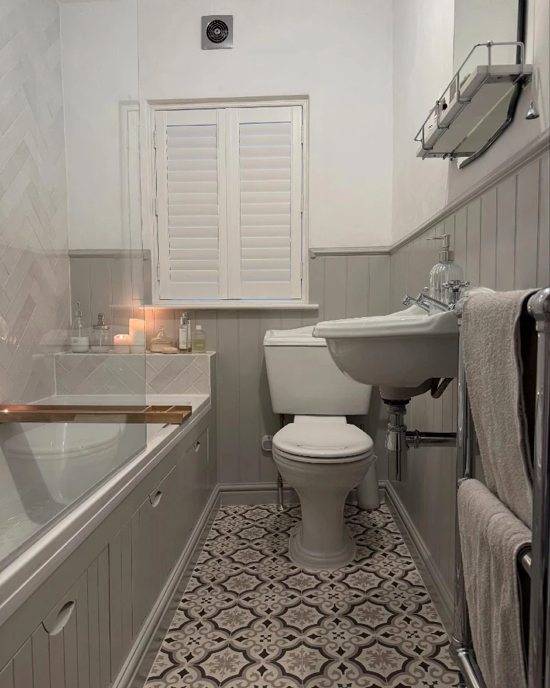 Soft Grey Shiplap Bath Panel with Intricate Patterned Floor Tile and Wall-Mounted Sink