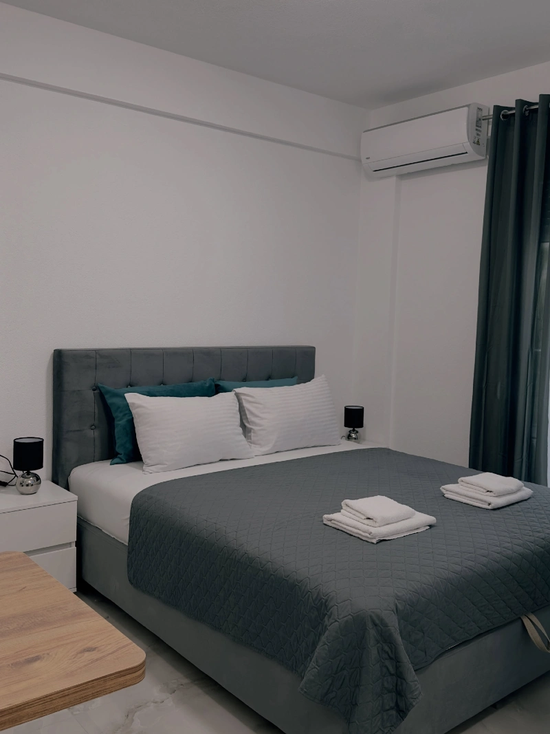 Soft Grey Upholstered Bed with Rust Throw and Vertical Wood Accent Panel