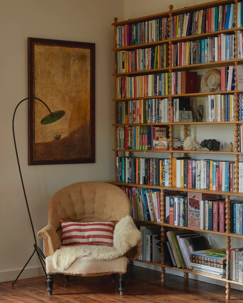 Spindle Wood Bookcase with Striped Pillow, Sheepskin Throw, and Arc Floor Lamp