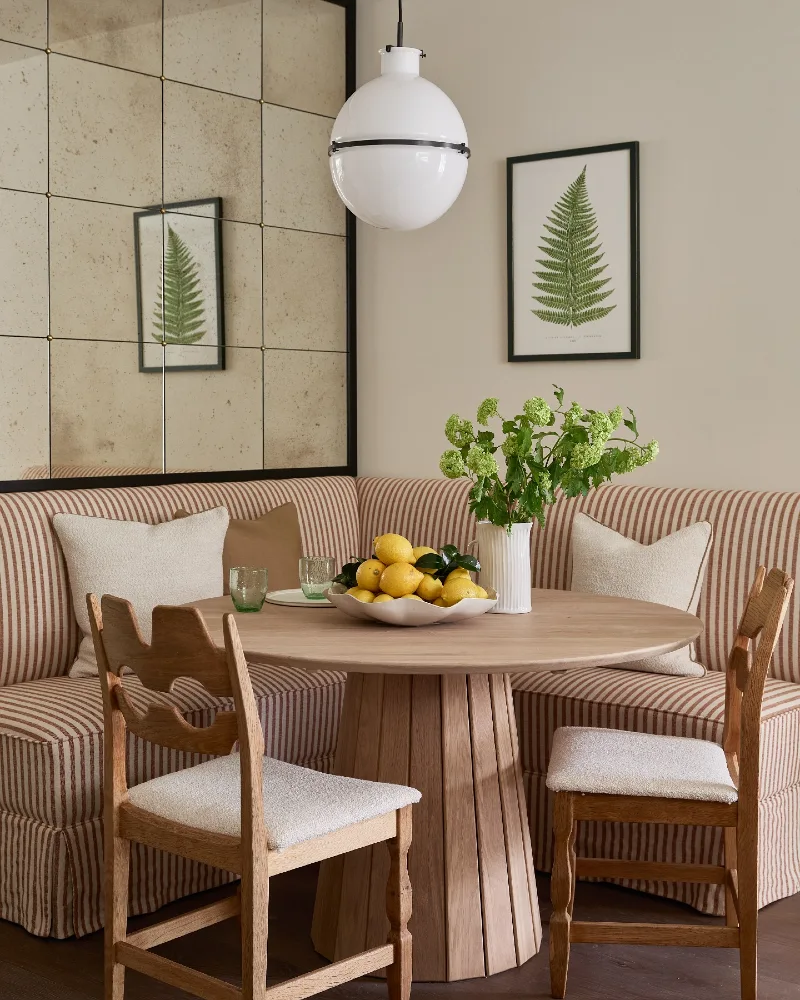 Striped Corner Banquette with Globe Pendant and Mirrored Wall Panels