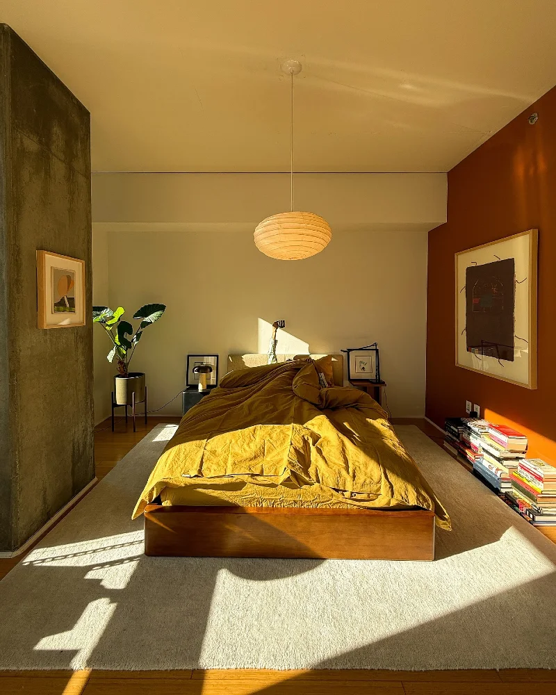 Sunlit Mustard Bed in Warm Industrial Bedroom with Split Texture Walls