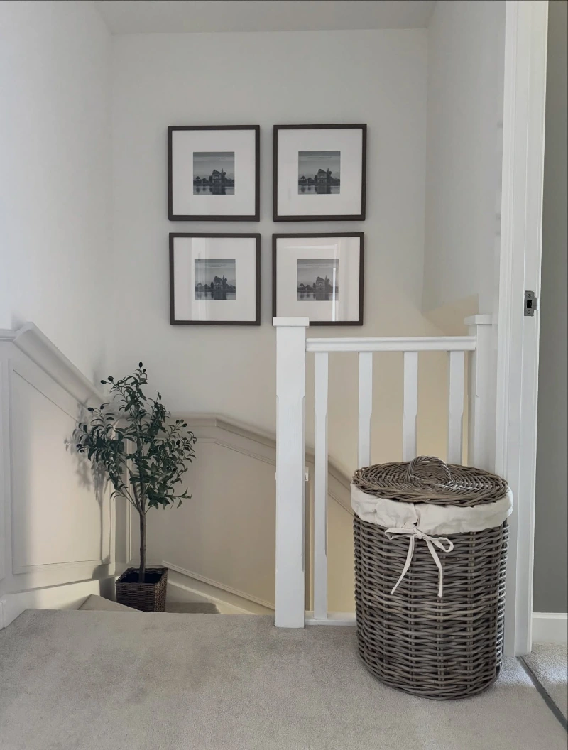 Symmetrical Four-Frame Grid Gallery Above a Woven Laundry Hamper