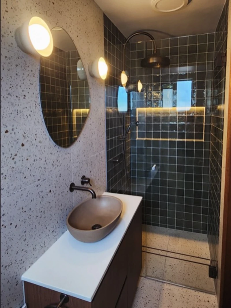 Terrazzo Wall Panels with Olive Square Tile Shower and Earthy Oval Vessel Sink