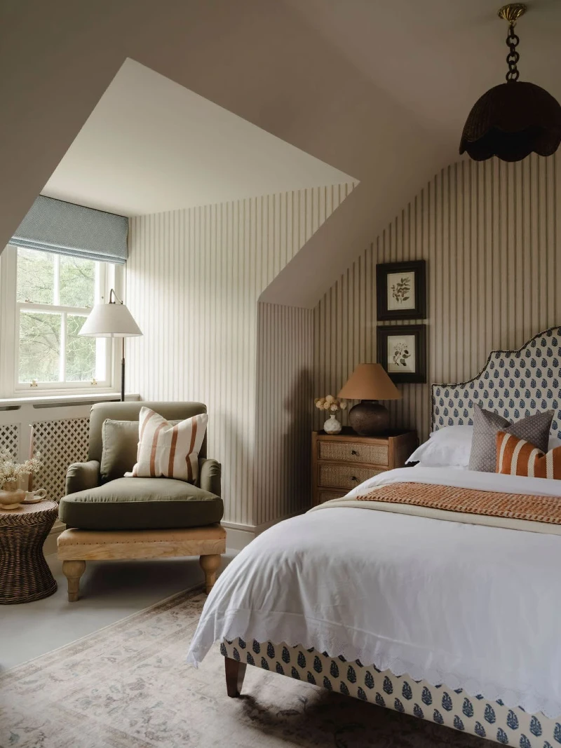 Vertical Striped Wallpaper with Blue Block-Print Headboard and Olive Green Armchair