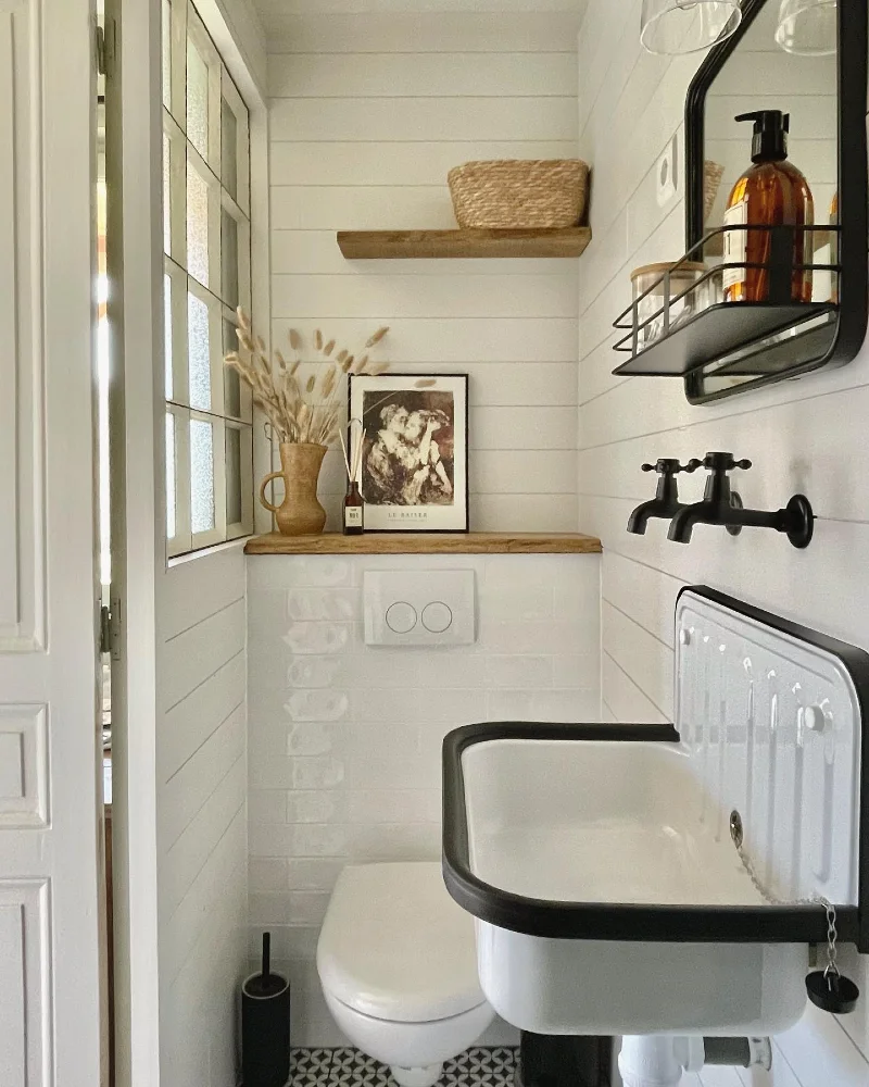Vintage Enamel Utility Sink with Black Wall-Mounted Faucets and Rustic Shiplap