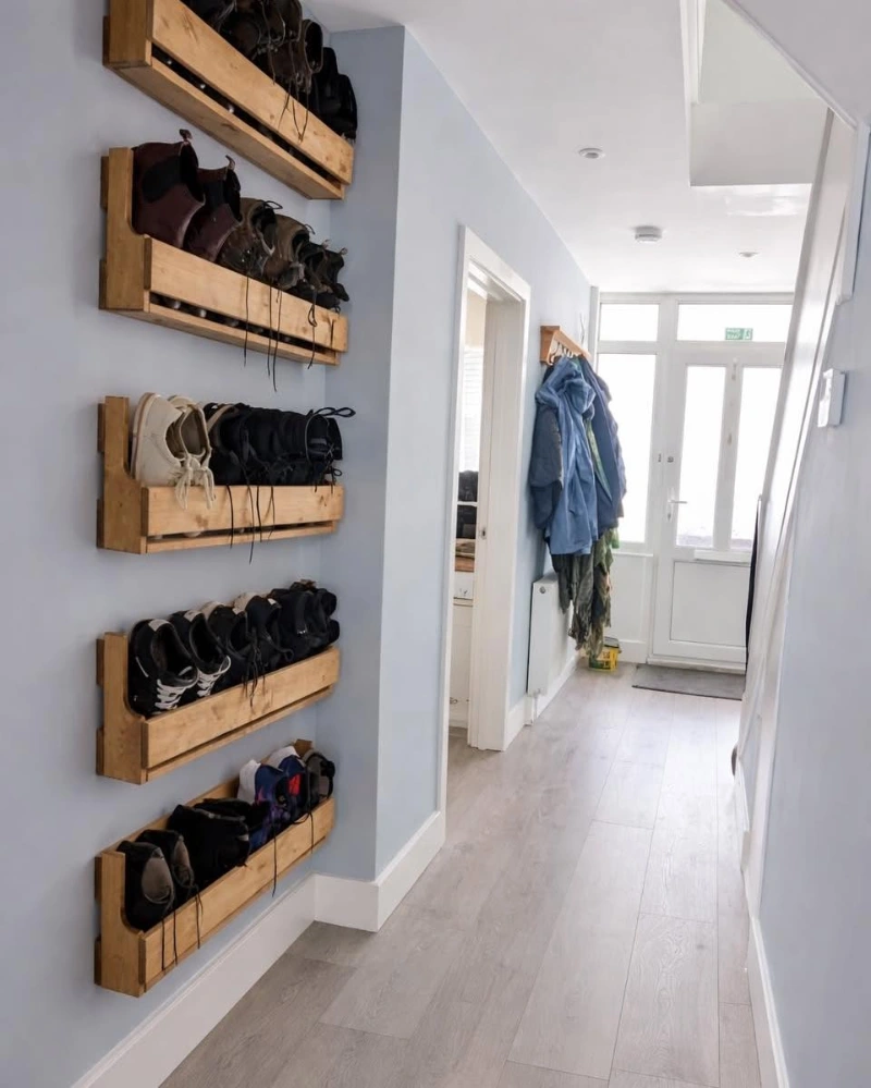 Wall-Mounted Wooden Pallet Crate Racks in a Narrow Light Blue Hallway