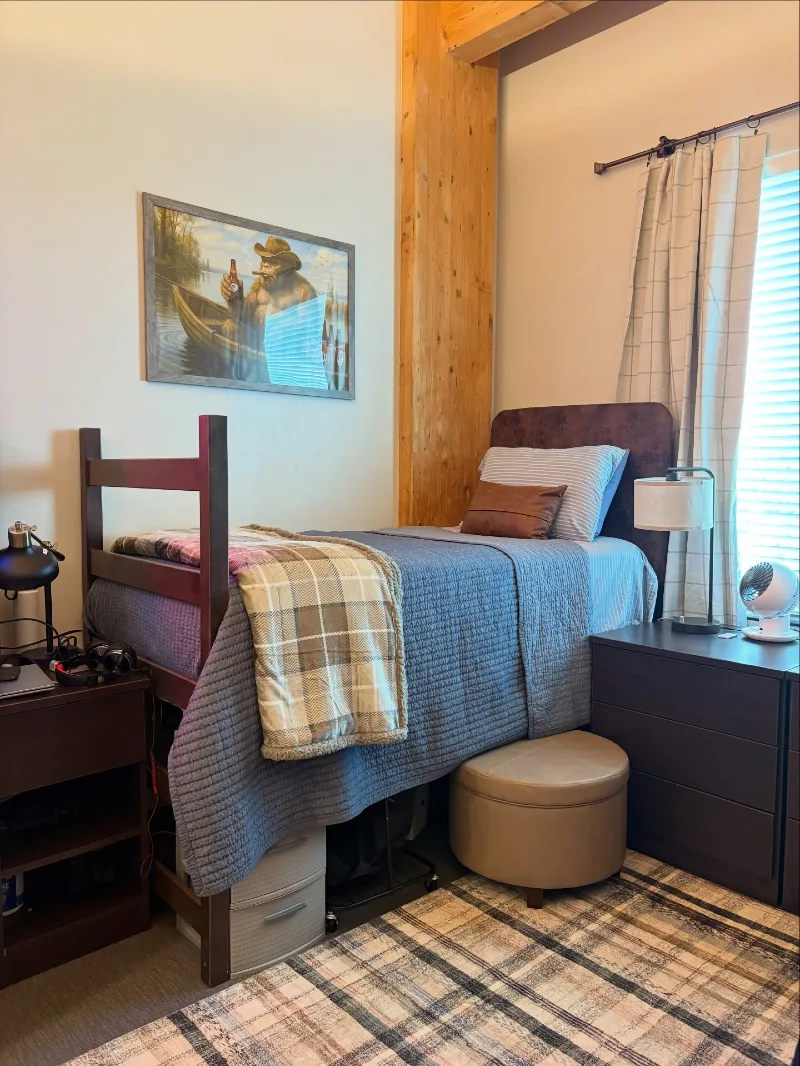 Warm Industrial Dorm Setup with Wood Accents and Layered Storage Under Bed