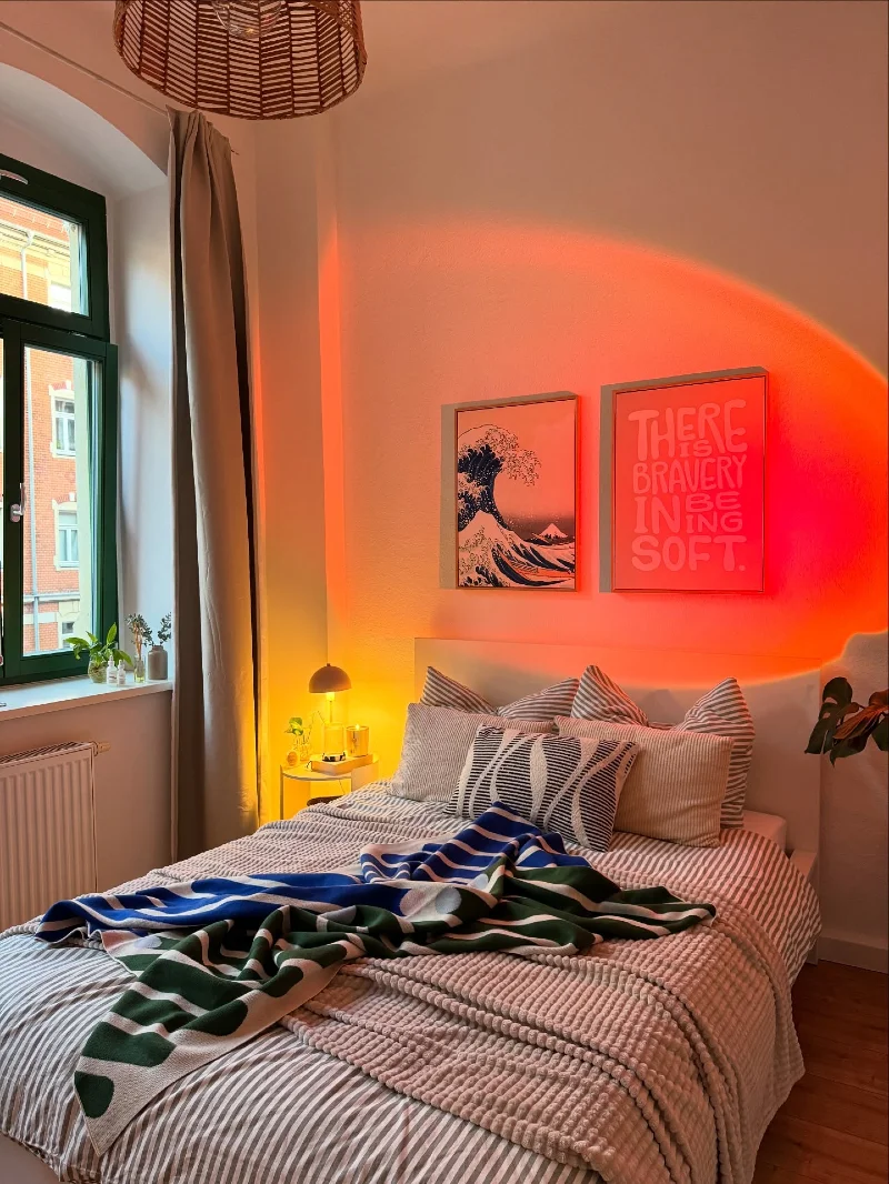 Warm Orange Glow Bedroom Wall with Framed Art Pair Above Striped Bed