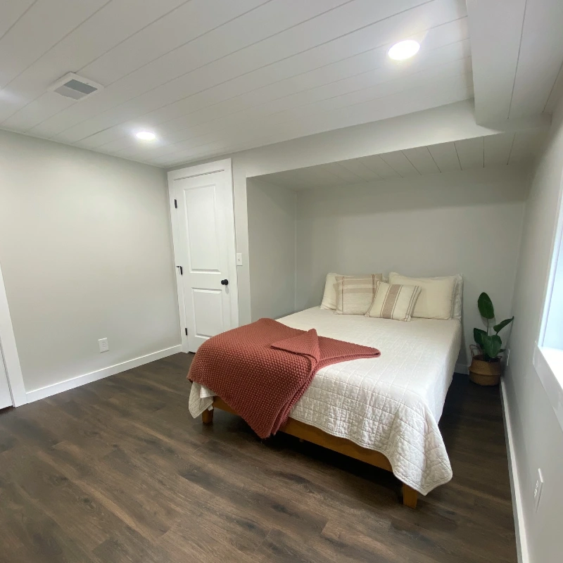 White Paneled Shiplap Ceiling with Recessed Bed Alcove and Terracotta Chunky Knit Blanket
