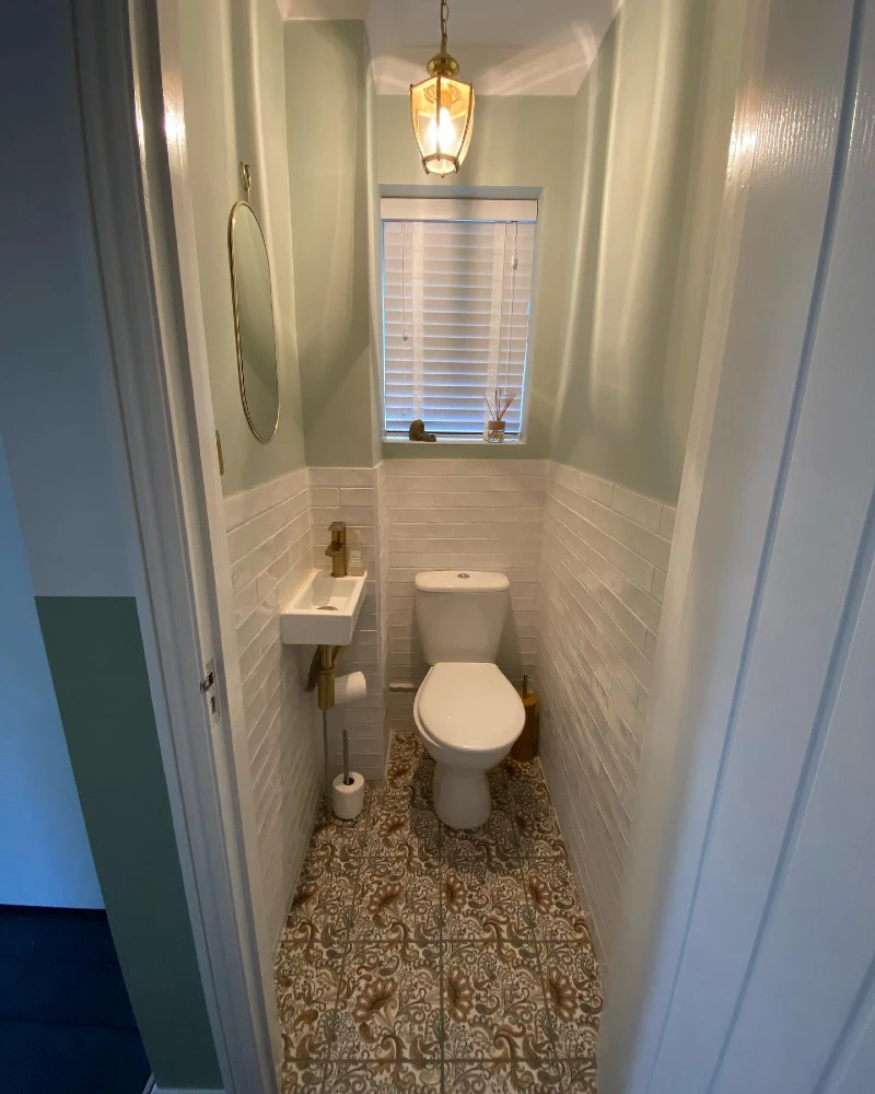 White Subway Half-Tile Walls with Sage Green Paint and Ornate Patterned Flooring
