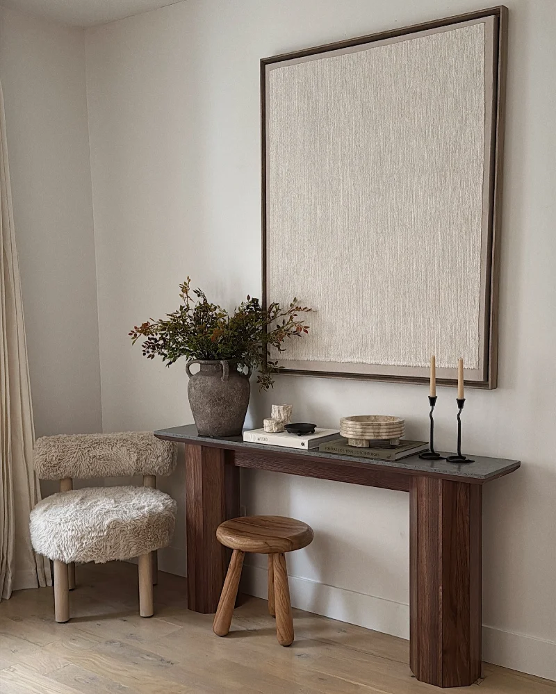 Wood Console with Textured Wall Art, Stone Vase, and Black Taper Candles