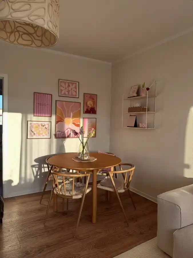 Wooden Round Dining Table with Pastel Pink Gallery Wall