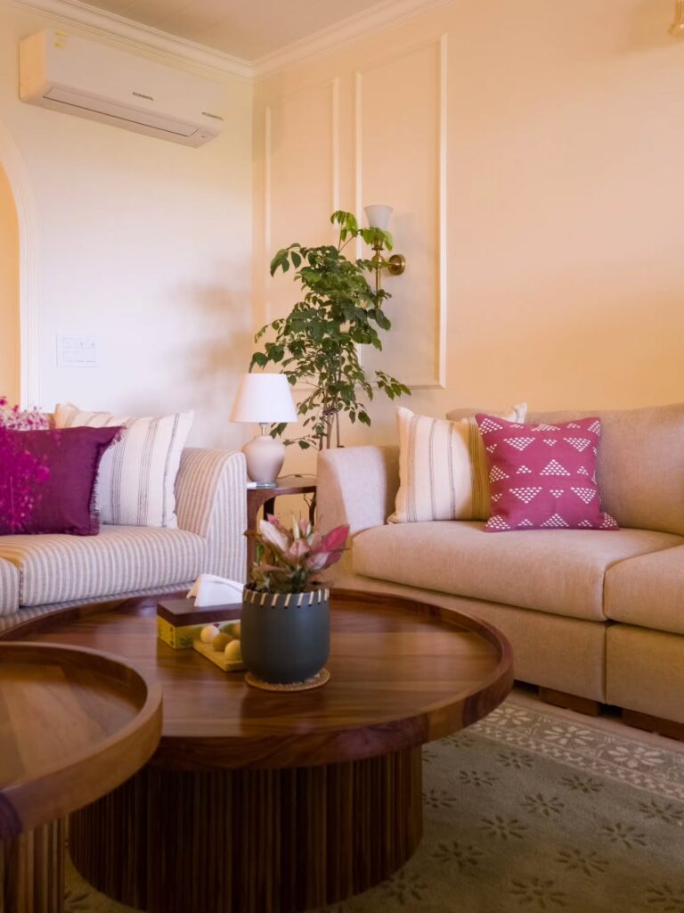 14. Round Ribbed Wood Coffee Tables with Beige Sofas and Berry Pillows