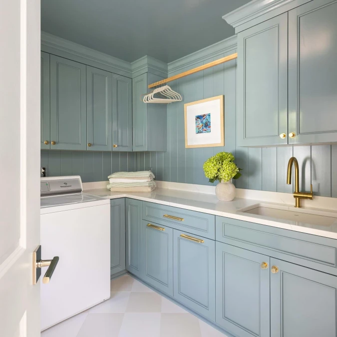 Airy Light Blue Laundry Room With Gold Accents