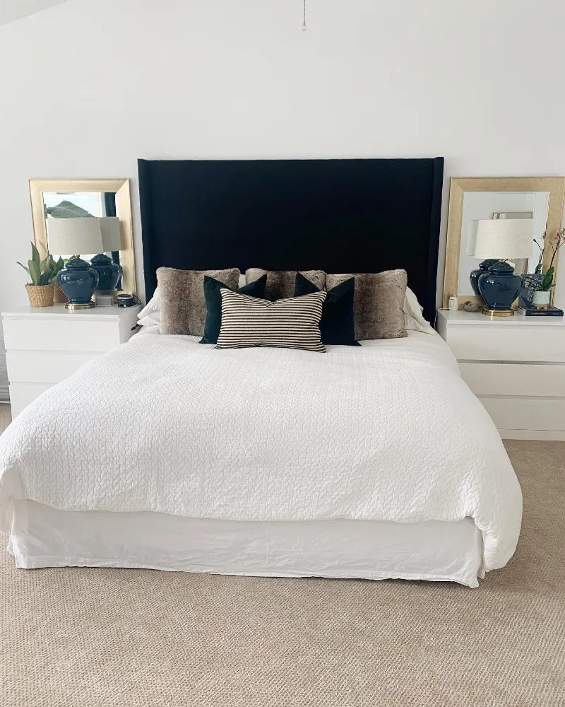 Black Fabric Headboard with Gold Framed Mirrors and Navy Ceramic Lamps