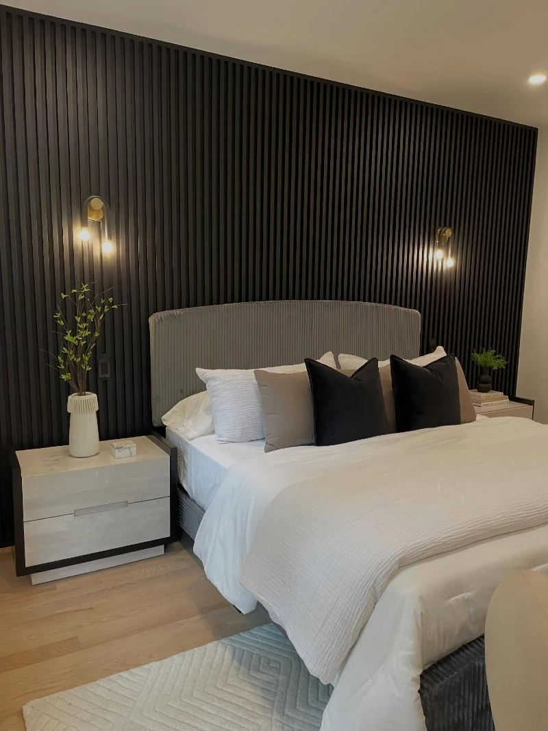 Black Fluted Slat Wall with Ribbed Grey Headboard and Warm Brass Sconces