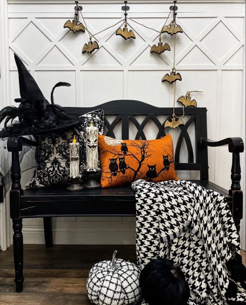 Black Wooden Entryway Bench with Graphic Textiles and Hanging Bat Garland