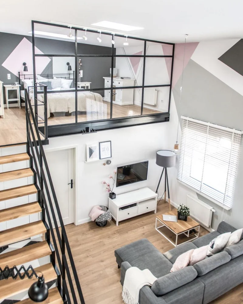Black grid glass room divider with geometric wall mural and lofted bedroom