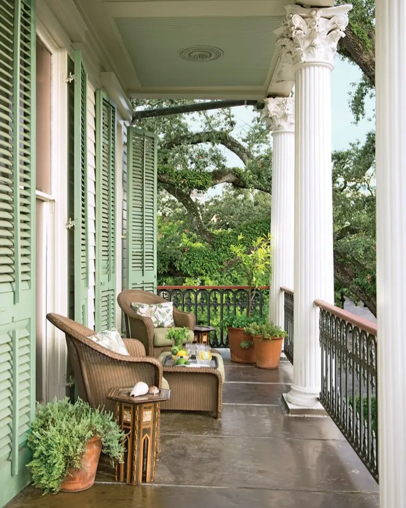 Brown Woven Armchairs with Soaring Sage Green Shutters and Fluted White Columns