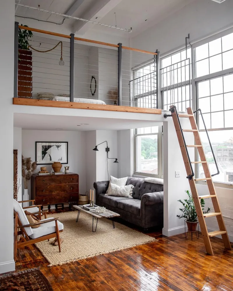 Cable railing mezzanine with wooden loft ladder and jute rug
