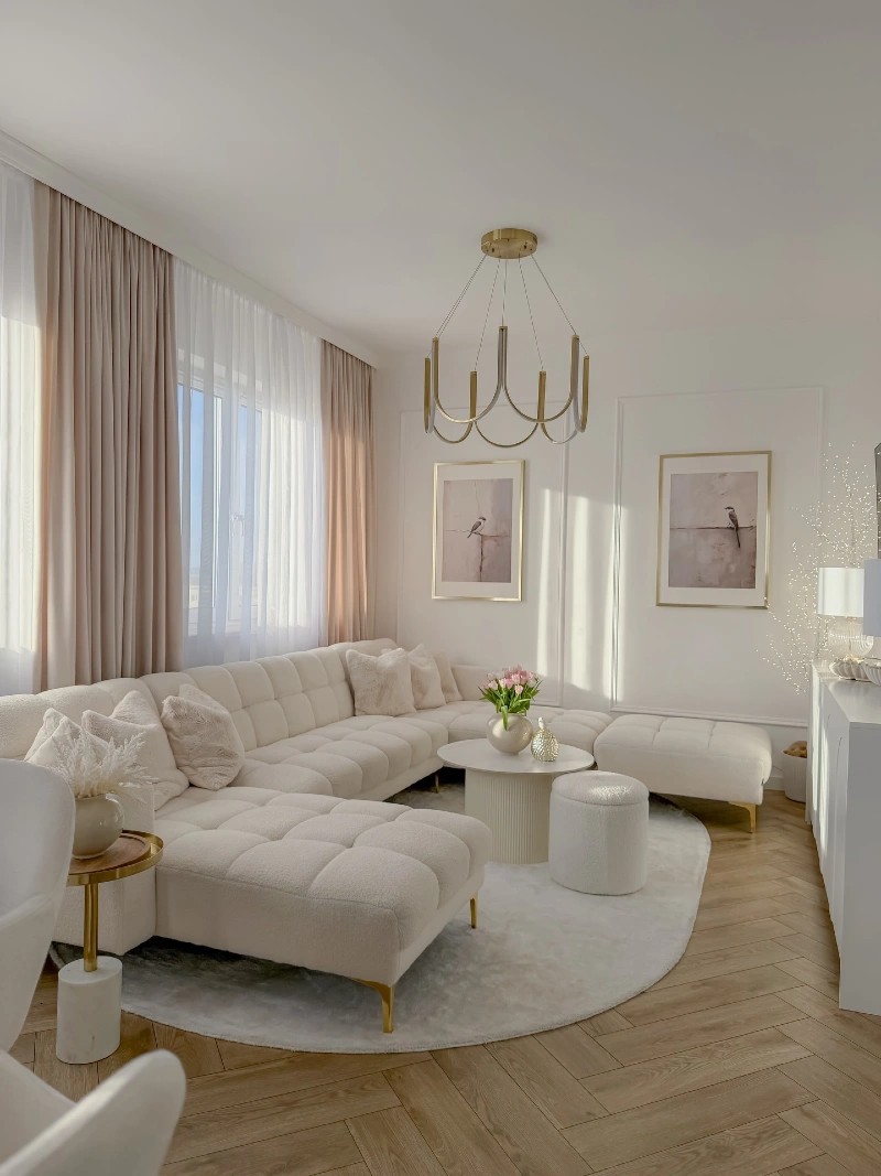 Channel Tufted Cream Sectional with a Brass Chandelier and Blush Drapes