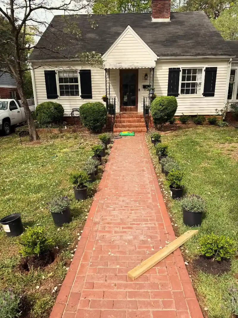 Classic Red Brick Walkway with Potted Greenery Lining the Path