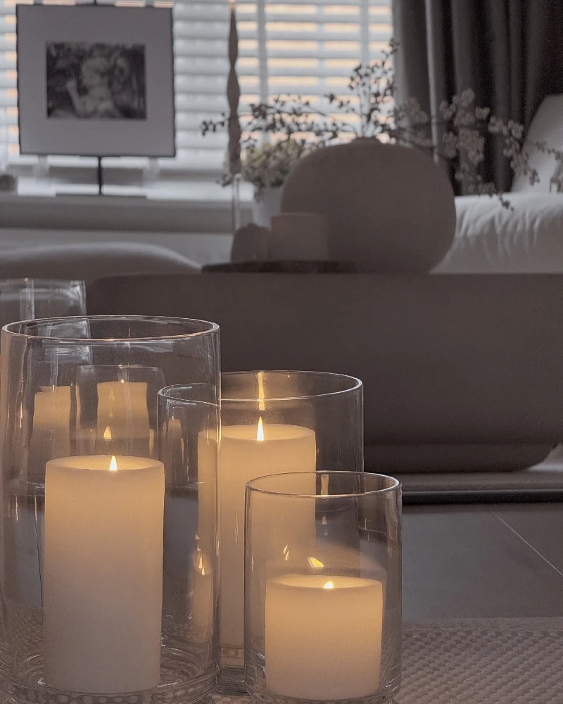 Clear Glass Cylinder Hurricanes with Large Cream Pillar Candles on a Low Table