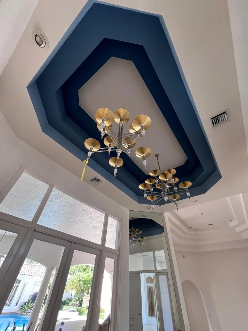 Concentric Hexagonal Tray Ceiling with Blue Recessed Borders and Dual Trumpet Brass Chandeliers