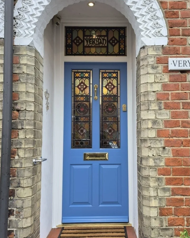 Cornflower Blue Front Door with Stained Glass Panels and Brass Hardware