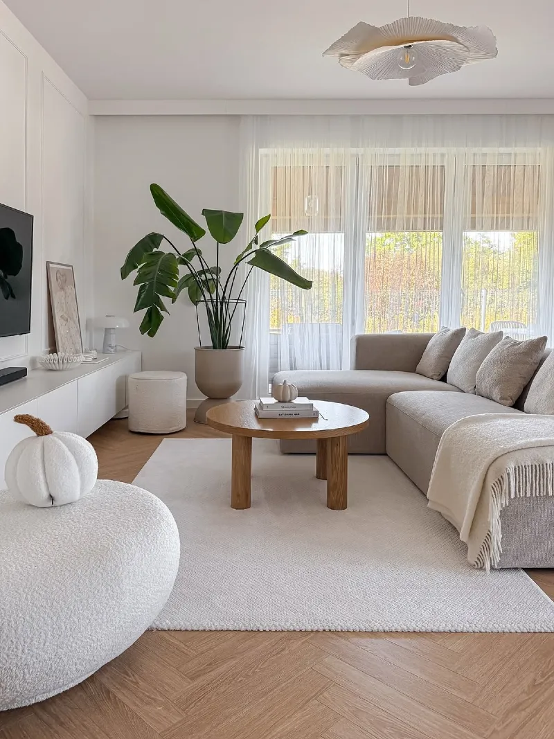 Curved Corner Sectional with a Round Oak Coffee Table and Statement Plant