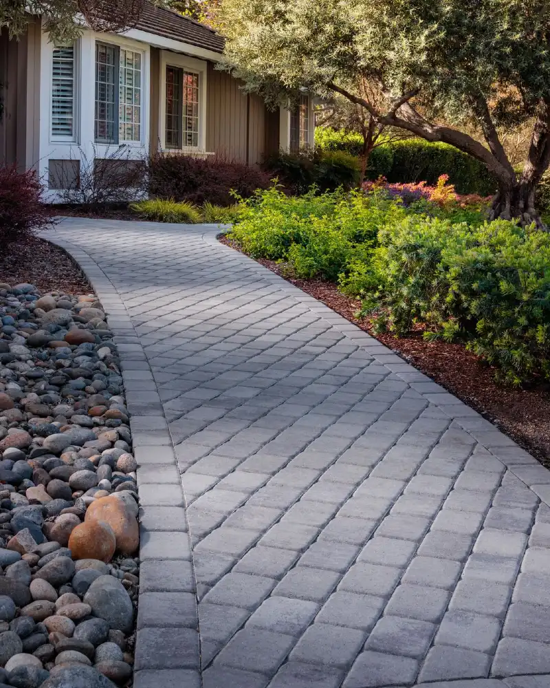 Curved Gray Paver Walkway with River Rock Border and Garden Canopy