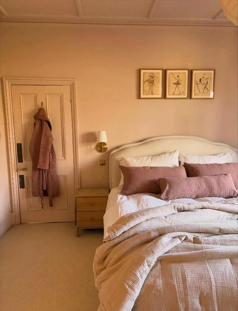 Curved Upholstered Headboard with Dusty Rose Linen and Framed Sketches