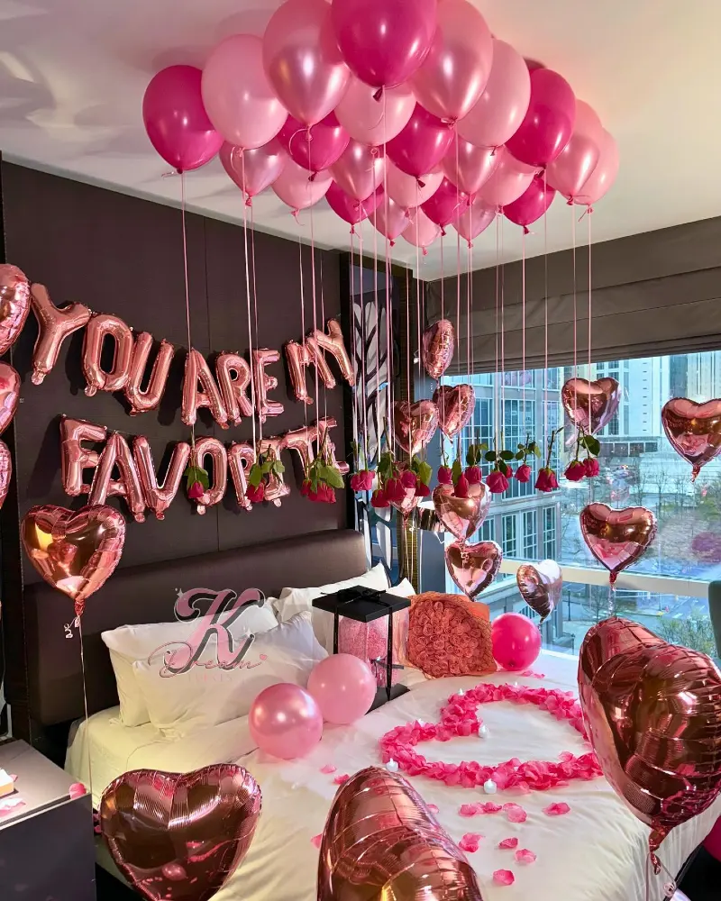 Dark Padded Headboard with Rose Gold Letter Balloons and Hanging Pink Rose Blooms