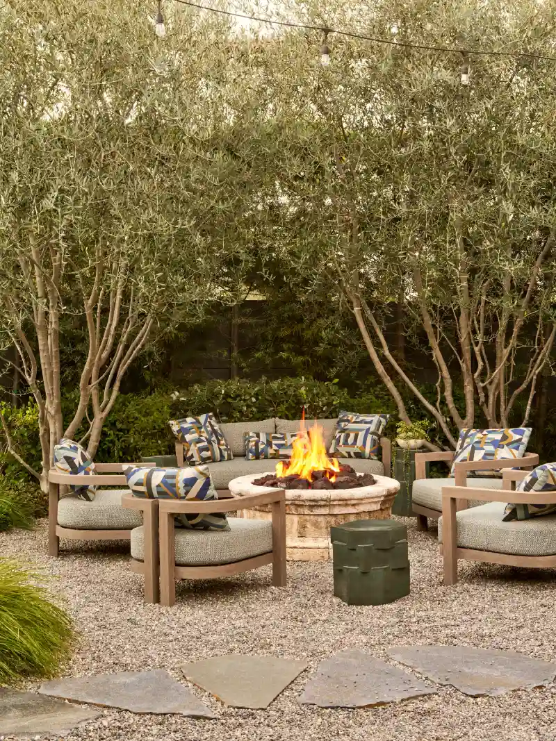 Deep Lounge Chairs Around a Limestone Fire Table Beneath Olive Trees