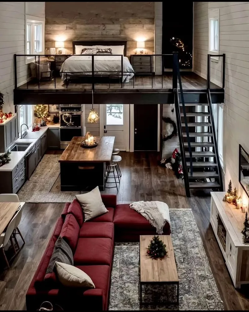 Deep red sectional sofa with rustic wood island and elevated loft bedroom