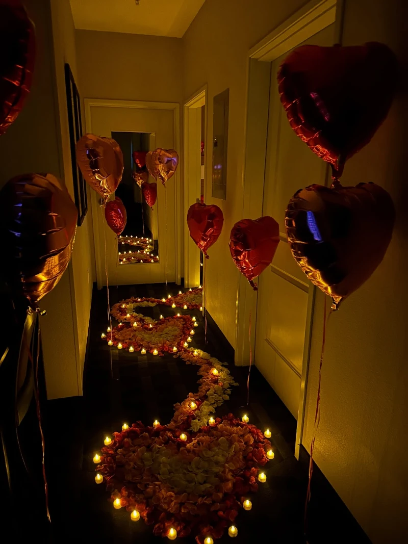 Dim Hallway with Curving Red and White Petal Path and Floating Foil Hearts