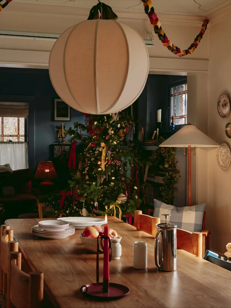 Dining Table with Paper Pendant, Deep Red Candles, and Festive Garland