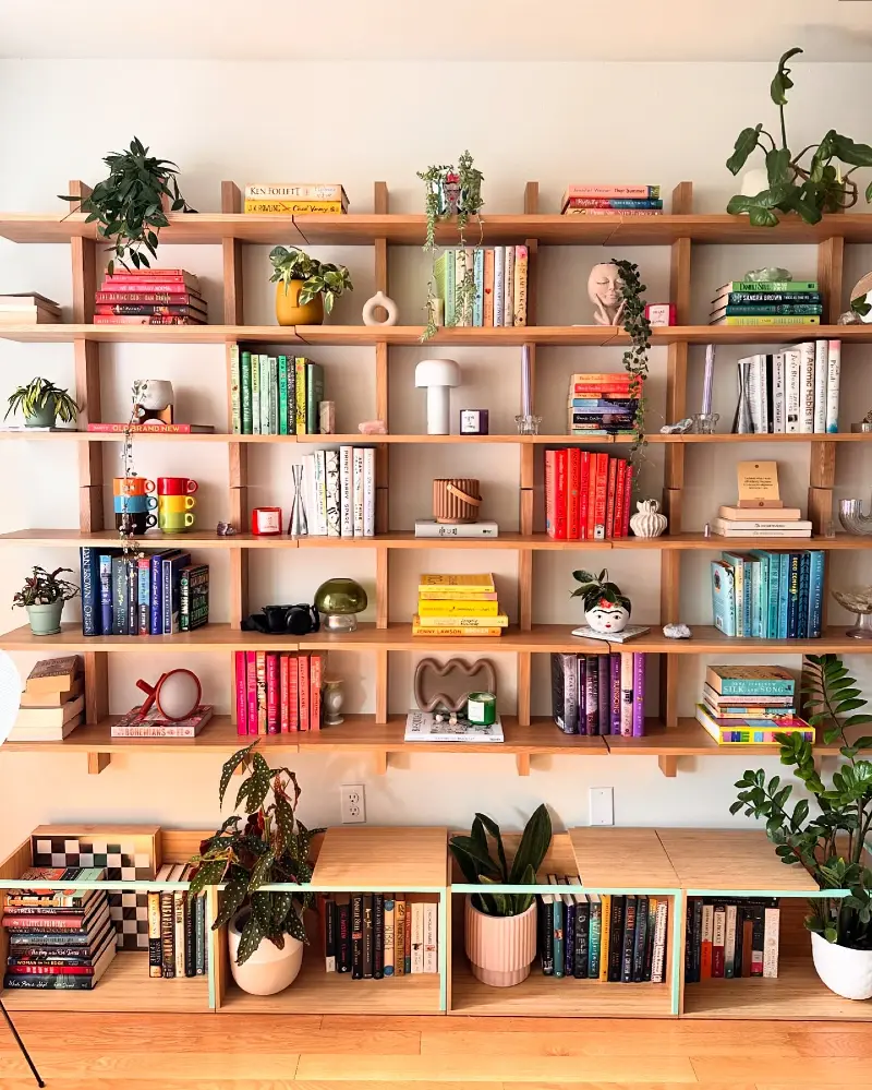 Expansive Grid Shelving with Layered Greenery and Color-Coded Reads