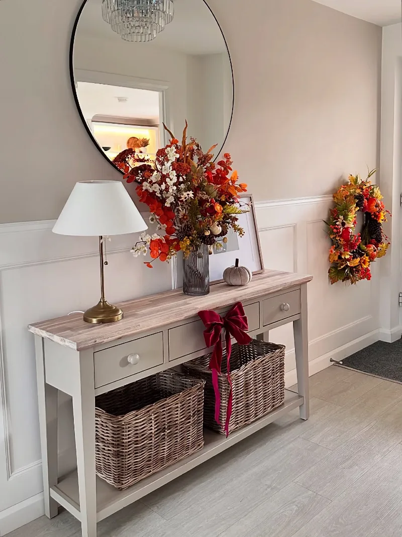 Grey Console Table with Fluted Amber Vase, Red Velvet Bow, and Colorful Autumn Wreath