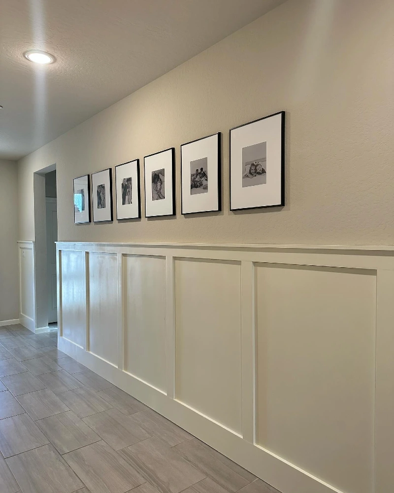 Horizontal Row of Black Framed Photography Above Board and Batten Wainscoting