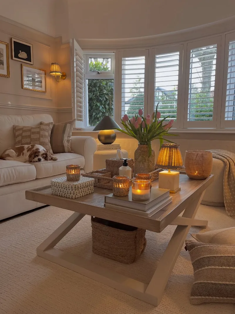 Light Wood X-Base Coffee Table with Pink Tulips and Glowing Votive Candles