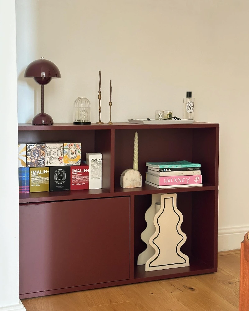 Low-Profile Burgundy Storage Unit with Sculptural Accents