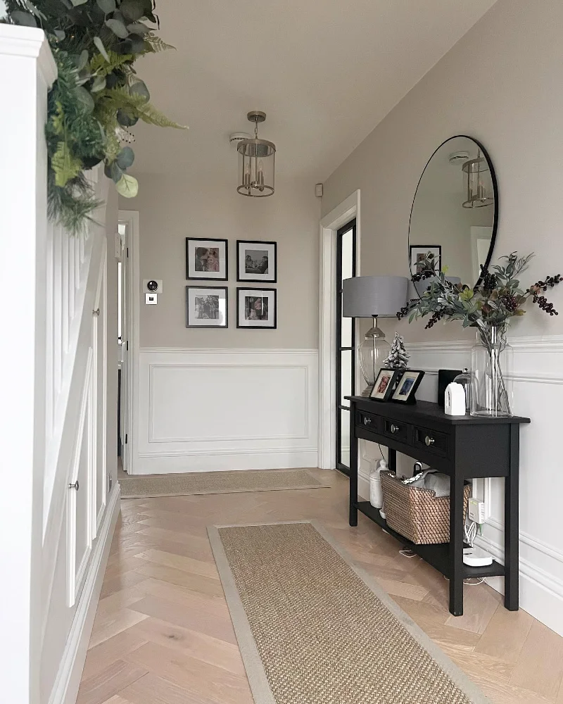 Matte Black Console Table with Round Mirror and Square Four-Frame Gallery Grid